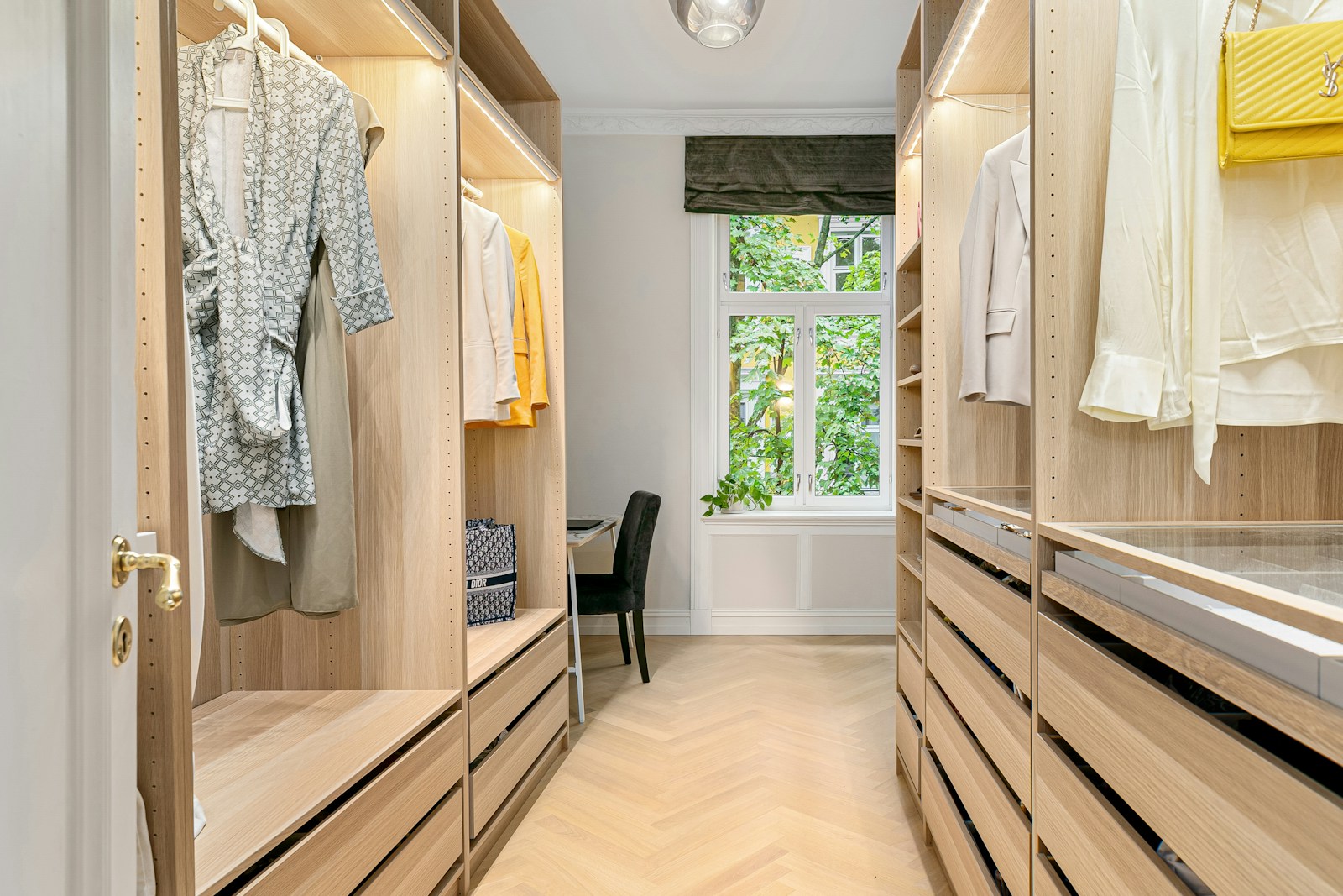 A walk in closet filled with lots of wooden drawers