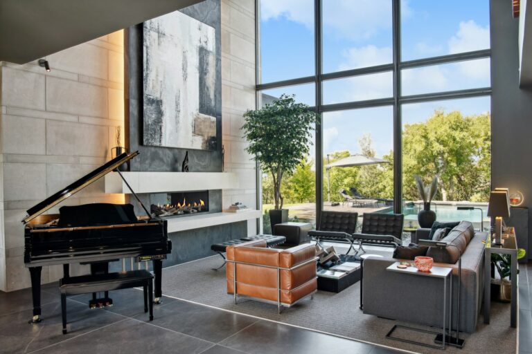 Modern living room with grand piano and large windows.